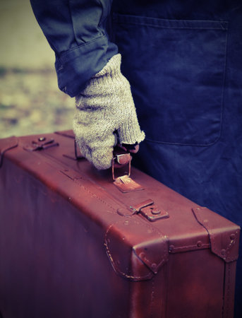 poor person with the old worn leather suitcase