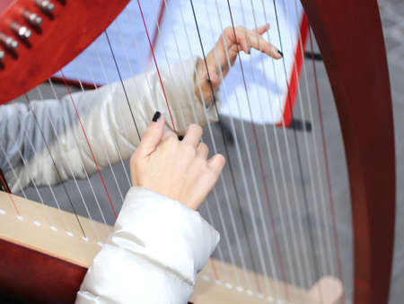 hands of a young woman playing gently the harpの写真素材