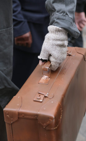 poor migrant with old leather suitcase and the broken glove during travel abroad