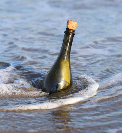 Secret Message in the glass bottle on the beach of oceanの写真素材