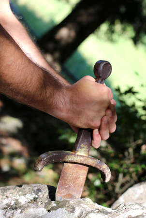 hand of a blockbuster Knight and the famous Excalibur sword in the stoneの写真素材