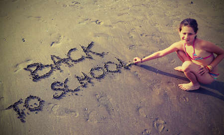 babe writes the Back to School on the beach in summerの写真素材