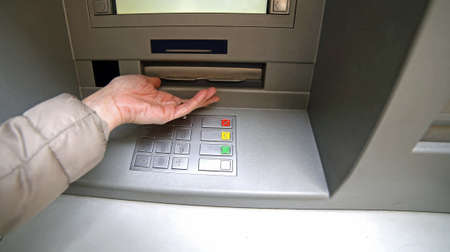 hand of woman while waiting the money from atm bankomatの写真素材