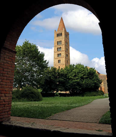 Ancient bell tower of the abbey of Pomposa surrounded by an arc of the monastery in Central Italyのeditorial素材
