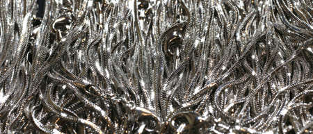 background of shiny anodized aluminum and braided necklaces for saleの写真素材