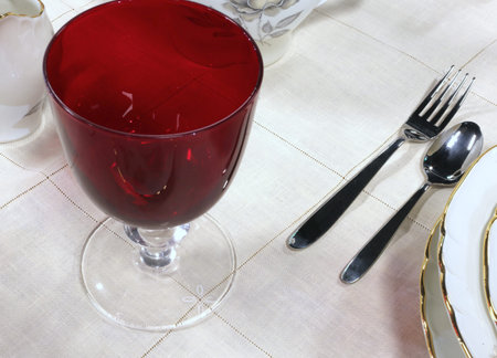 red crystal glass with fork and spoon on the table of the restaurant