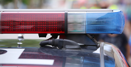 large red and blue flashing lights on the police car on patrol in the city