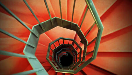 very long red spiral staircase without endの写真素材