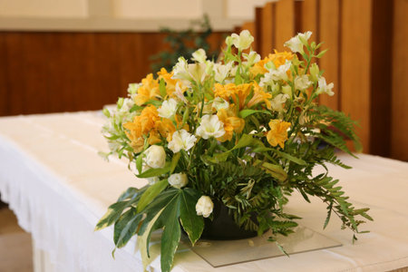 vase of beautiful flowers on the altar in the church during the weddingの写真素材