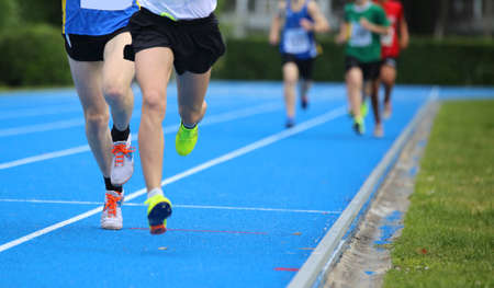 many young athletes during the race run on the athletics trackの写真素材