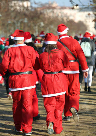 people run during the sporting event called Running with Santa Claus in the public park of the city at Christmasの写真素材