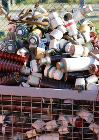 full basket in a landfill with pollution ceramic material and many old electrical insulatorsの写真素材