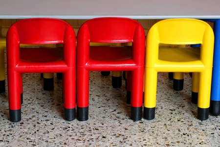three colored plastic chairs in a nursery for small childrenの写真素材
