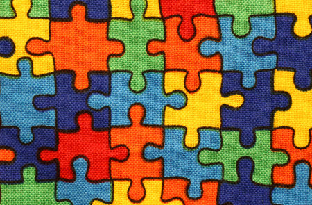 background of  fabric with pieces of multicolored puzzle