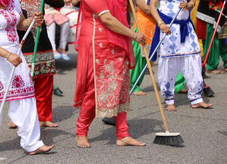 many barefoot women Sikh sweep the road during the ceremony along the streets of the cityの写真素材