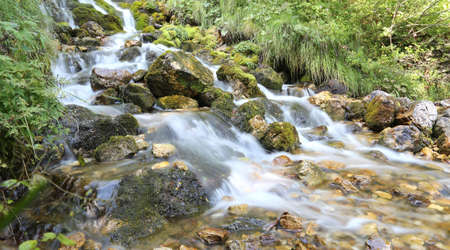 wonderful mountain stream with water that seems in motion photographed with a long exposure timeの写真素材