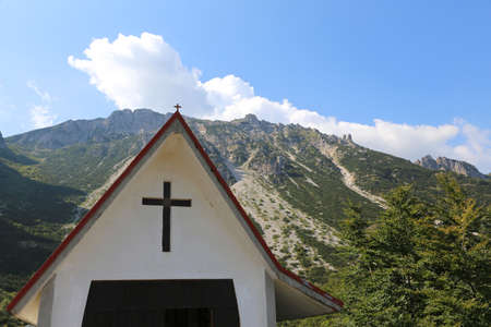 Christian church with the symbol of the cross at the foot of the Italian Alpsの写真素材