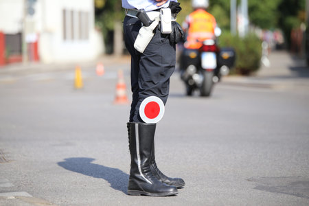 black boots and traffic pallet of a traffic warden in the city street