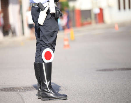 traffic warden controls traffic blacks wearing the uniform with black bootsの写真素材