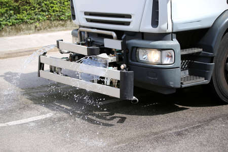 tank truck for cleaning the street in the city with a powerful jet of waterの写真素材