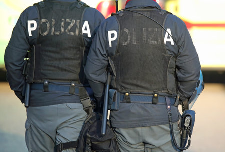 two Italian policemen in riot gear with the word POLIZIA meaning police in Italy