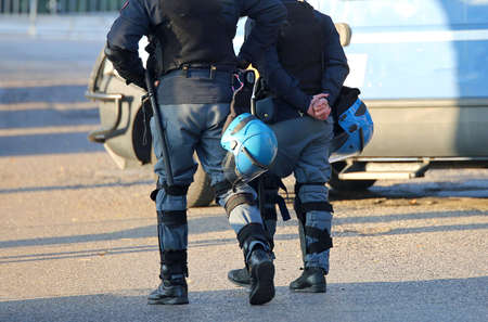 police in riot gear with helmet waiting for the fans of the soccer teams before the important matchの写真素材