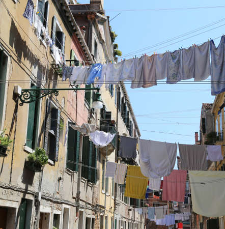 Venice Italy so many clothes hanging in the narrow streetの写真素材