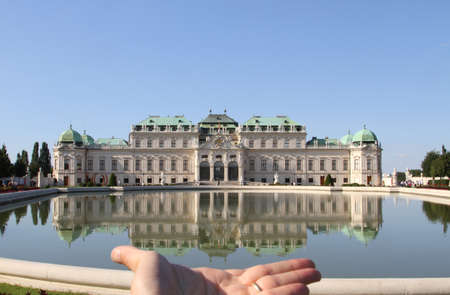 Vienna, Austria - August 28, 2014: reflection of the Upper Belvedere Castle on the lake and a big handのeditorial素材