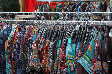 stall with many used  vintage clothes hanging for sale