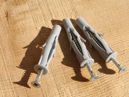 three anchors to secure the materials on the wall and rough wooden backgroundの写真素材