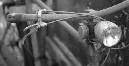 Old rusty bicycle with still functioning headlightの写真素材