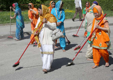 Vicenza, Vi, Italy - April 8, 2017: Sikh religious  barefoot women sweeping the street with brooms during the Nagar Kirtan festivalのeditorial素材