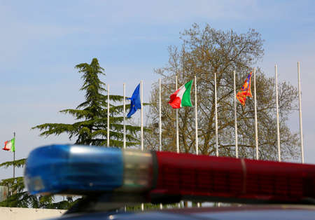 Police car sirens with blurry effect and European and Italian flags in backgroundの写真素材