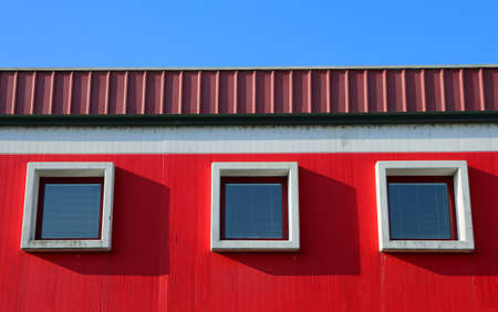 three square windows in the modern building and blue skyの写真素材