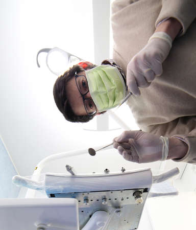 Professional dentist with green mask and tools and latex glovesの写真素材