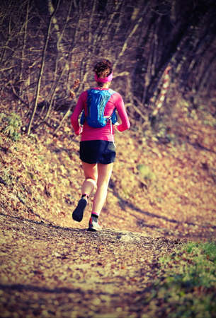 Woman runs fast with the sport suit in the mountain trail in winterの写真素材