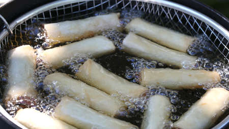 Pot with hot oil during cooking by frying spring rollsの写真素材