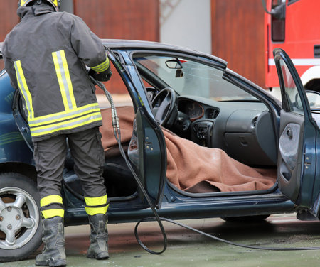 Firefighter team pulls the man wounded by the car after a serious road accident