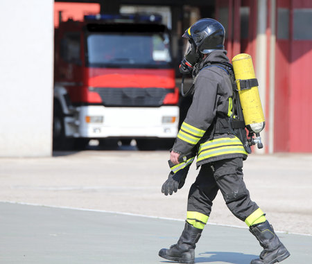 Firefighter with large yellow oxygen cylinder and automatic respirator
