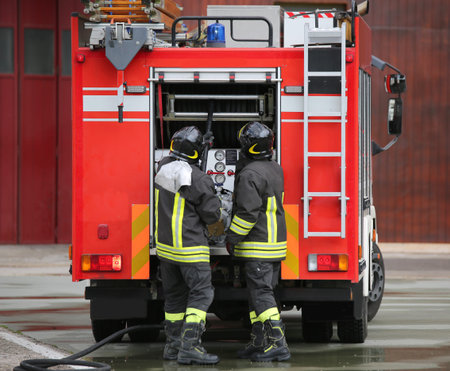 Two firefighters and the fire truck during a mission