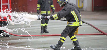 Firefighters while extinguishing the fire with a special fire extinguishing equipment with foma