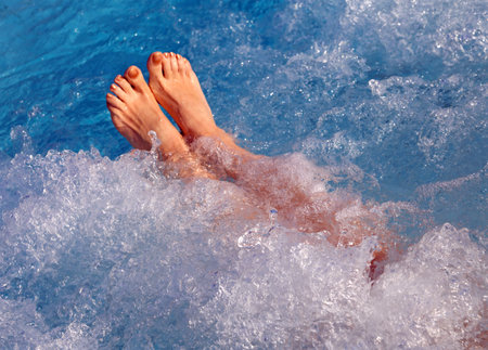 Young girl doing the hydromassage in the pool of the spa