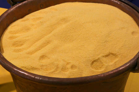 Yellow wheat flour in old copper cauldronの写真素材