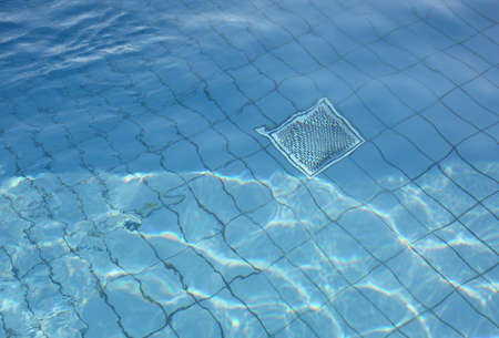 Background with clear pool water and metal grill for recirculation and purificationの写真素材