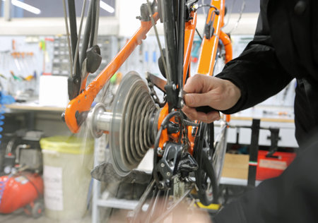 Hand of the young mechanic while fixing the bicycle inside the mechanical workshopの写真素材