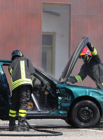 two Firefighters check the incident car after the car accident