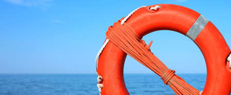 Orange life buoy for the rescue of personsand the sea on backgroundの写真素材