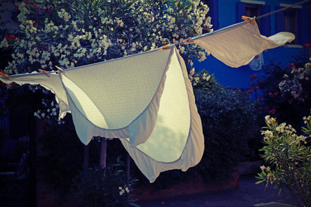 bed sheets spread to dry in the sun in a small village in the mediterranean areaの写真素材