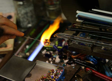 Warm flame used by the vetraio artist while modeling the glass in his craft shop in Italyの写真素材