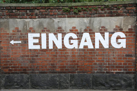 large white text EINGANG on the brick wall which means EXIT in germanの写真素材